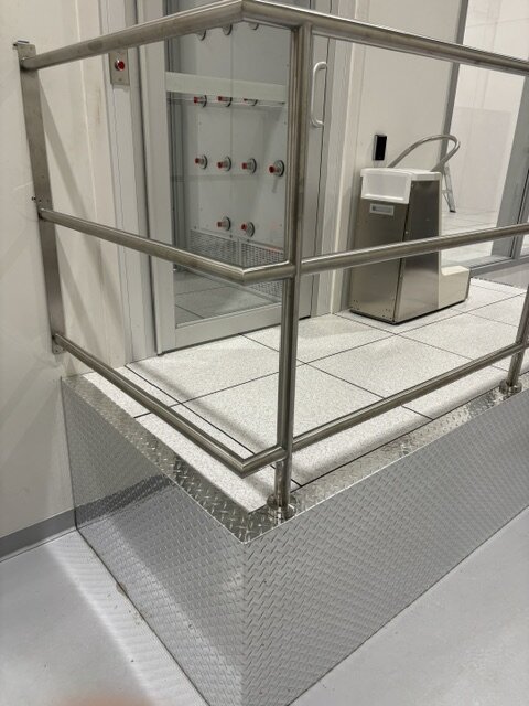 Stainless steel guardrail on a raised access floor platform with diamond plate fascia at Photonics, Vancouver