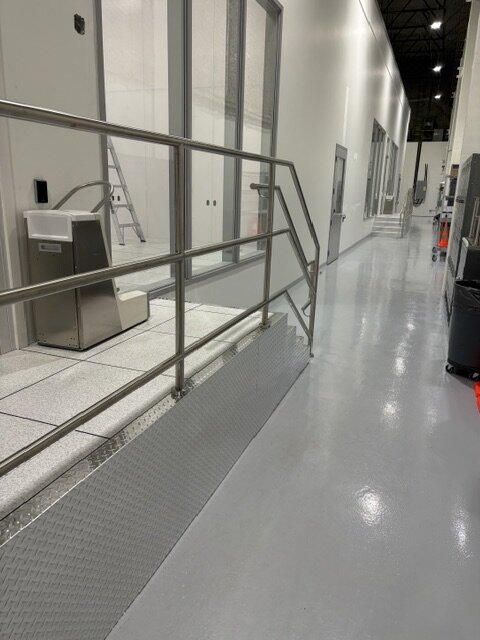 Stainless steel handrail along an access floor platform and stair at Photonics, Vancouver